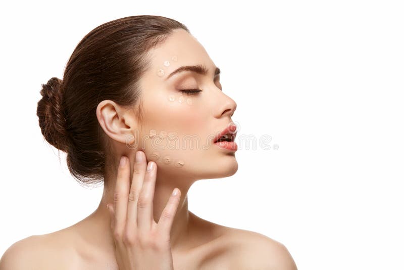Girl applying foundation on face isolated on white stock photos
